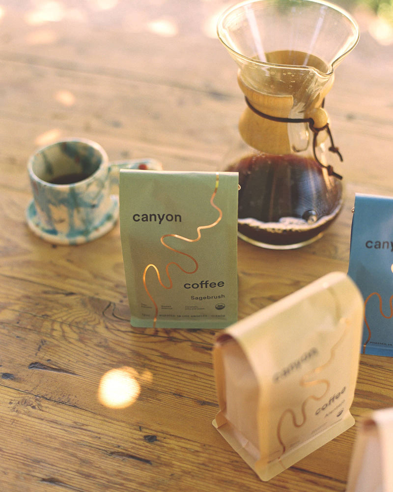 canyon coffee displayed with a pour over on a wood table