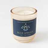 Blue Spruce Candle: Cream soy wax in glass jar, navy label—festive scent from Santa Barbara Company.