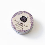 A round tin of California Mission Fig & Honey Lip Shimmer from Three Sisters Apothecary on a white background.
