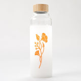The California Poppy Water Bottle is a clear glass bottle with a bamboo lid, featuring a white sleeve decorated with orange California poppy flowers and buds.