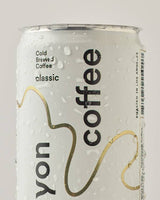 A close-up of a Canyon Cold Brew Coffee can labeled "classic," chilled and covered in water droplets.