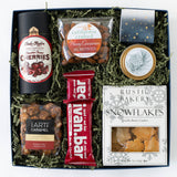 Holiday gift box with snacks, cookies, and a bar on a white background
