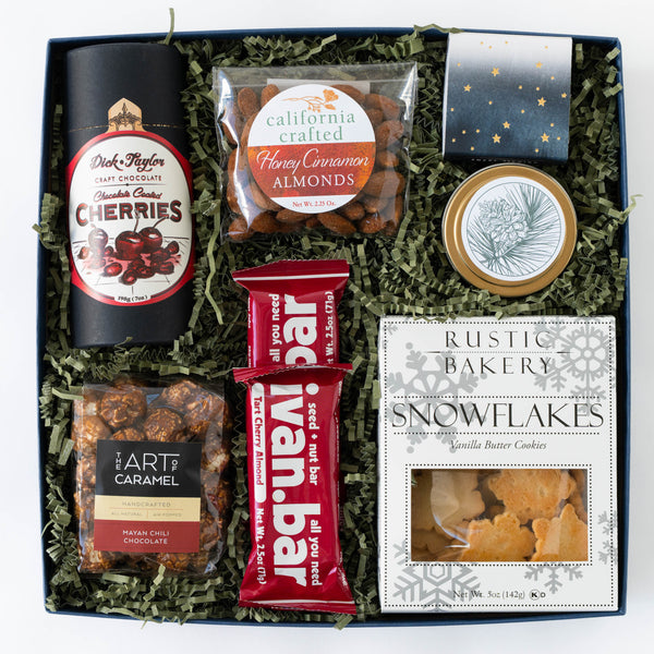 Holiday gift box with snacks, cookies, and a bar on a white background