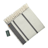 A cream-colored organic striped cotton throw blanket with dark gray stripes, fringed edges, and a green "Zentree" tag, featuring custom logo embroidery.