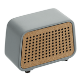 The Custom Logo Stone Bluetooth Desk Speaker features a small, rectangular light gray stone body with a cork front panel of circular holes, sits on four feet, and is ideal for laser-etching your custom logo.