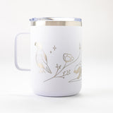 The Golden State California Insulated Camp Mug is a white mug with a metal rim and handle, featuring minimalist gold line art of a bird, flower, and small animal on a plain white background.