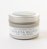 A small silver tin labeled "Goleta Bluffs Travel Candle" (3oz soy wax) with a decorative lid is set against a white background.