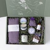 Lavender Restorative Gift box open to show a linen eye pillow, soy candle, lavender sachet, balm, room mist, bath soak, and chocolate covered almonds