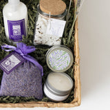 Deluxe Lavender Gift Basket with bath salts, lotion, sachet, soy candle, and decorative shredded paper.
