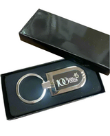 The Official Fiesta Centennial Keychain comes in a black gift box and features "100 Years Arista Fiesta" with a celebratory logo on a silver keychain—an ideal keepsake for the 100th anniversary.