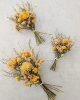 Three Garden Dried Floral Bouquets feature yellow and beige preserved flowers, tied with string on a textured background.