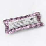 A wrapped Raspberry & Medjool Date Dark Chocolate Bar with a purple checkered pattern label, featuring raspberry flavor, organic dark chocolate, sweetened with coconut sugar, and filled with Medjool dates.