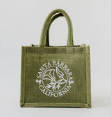 The Santa Barbara Poppy Small Tote is a sustainable green jute bag with two handles, featuring a white California poppy graphic and “Santa Barbara California” on the front.