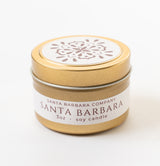 The Santa Barbara Travel Candle is a 3oz clean-burning candle in a small gold tin with a floral lid design and a white label reading Santa Barbara Company, Santa Barbara, shown on a white background.