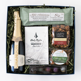 The Sparkling Treats Gift Box features California sparkling wine, a Dick Taylor organic chocolate bar, chocolate-covered hazelnuts, artisan almonds, a date-filled dark chocolate bar, and two small jars with gold lids.