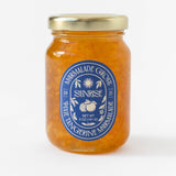 A clear glass jar with a gold lid and blue label displays Sunrise Pixie Tangerine Marmalade, 5 oz (141g), 2021. This handmade marmalade captures the true, fresh flavor of Ojai tangerines.