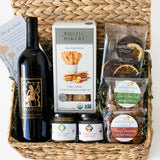 Gourmet food gift basket with Petite Sirah wine, crackers, California nuts and other snacks in a woven gift basket