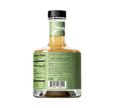A bottle of Tilden Non-Alcoholic Cocktail - Lacewing with a green label displaying nutrition facts, ingredients, and a barcode on the back holds a light brown drink. It’s sealed with a black cap and stands out against the white background.
