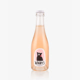 A clear glass bottle of Woody's Non-Alcoholic Sparkling Rosé (187ml) with light pink liquid and a label featuring a black bear design with pink accents, shown against a plain white background.