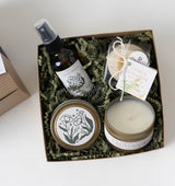 California Spa Gift Box with spray, citrus bath bomb, travel candle, and melts on white shredded paper.