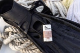 A Tinted Sunscreen Stick SPF 30 rests on black fins, coiled white rope encircling it.