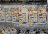 Carly's Map of Santa Barbara Canvas Totes with yellow ribbons are neatly lined up on metal shelves.