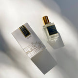 Sunset Noir Perfume Oil: Handmade, phthalate-free scent in a gold-capped bottle with an ASHÉ NOIR box.