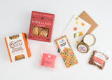 Pumpkin Spice Alfajores Cookies, autumn snacks, almonds, thank you card & candle on a white background.