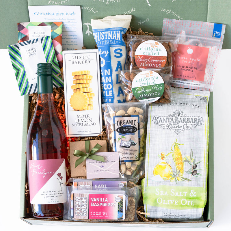 Gift basket with wine, snacks, and other products on a white background