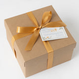 SB Scene Gift Box: Brown box with golden ribbon, Local & Sustainable Gifts tag—includes organic pistachios.