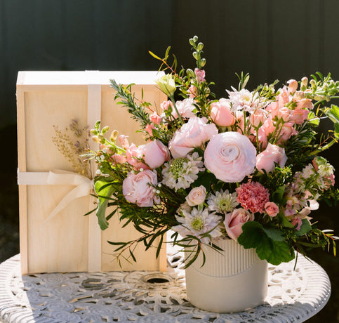 pink floral arrangement with gift box