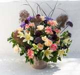 Champagne + Flowers: Large fresh arrangement of lilies, roses, dahlias, hydrangeas & greenery in a round vase.
