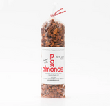 A clear bag of Paso Almonds Sweet Hot Brittle, filled with roasted California almonds, on a white background.