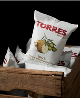Torres Olive Oil Potato Chips from Spain in a wooden crate, set against a black background.