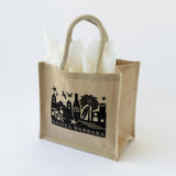 Santa Barbara Skyline Tote in Black: Beige jute bag with rope handles, white tissue—ideal for wine and snacks.