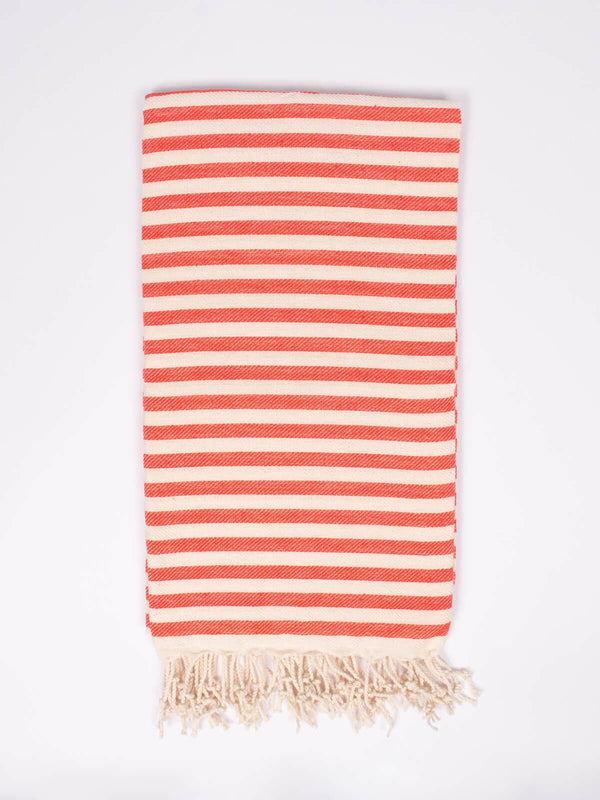 Folded striped orange and cream towel, with cream colored tassels