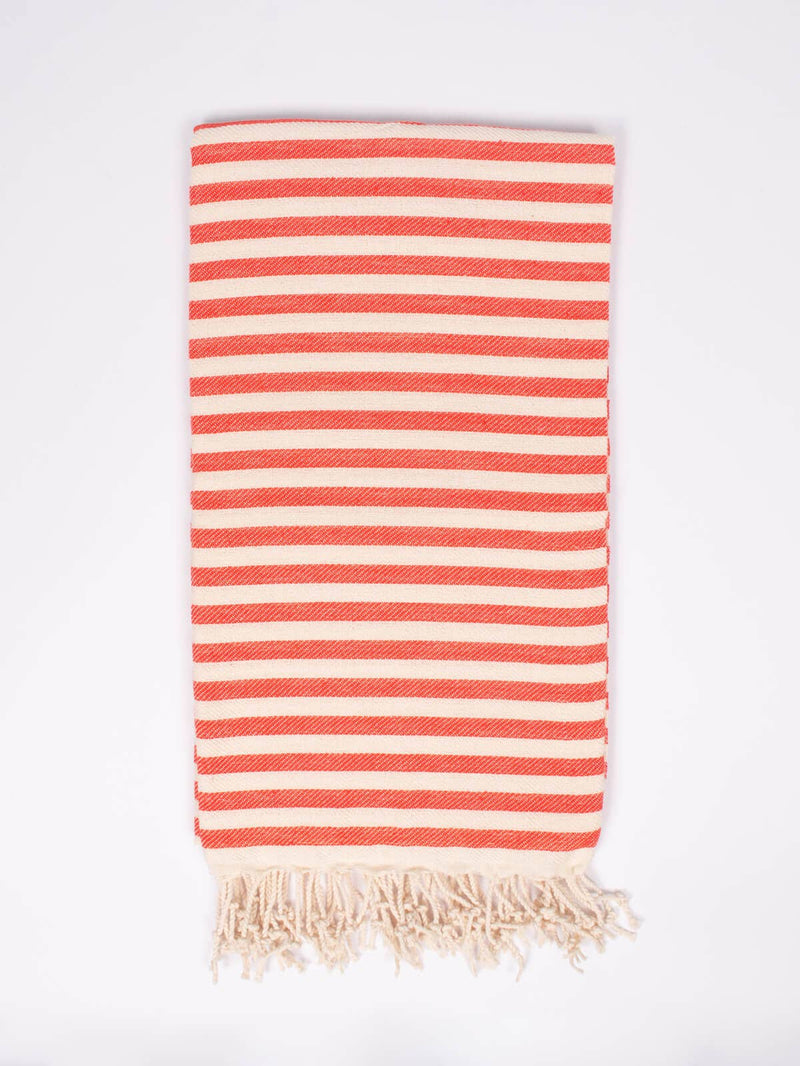 Folded striped orange and cream towel, with cream colored tassels