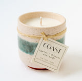 The Coast Ceramic Soy Candle is a 6oz handmade soy wax travel candle by Santa Barbara Company, featuring green and cream glazed ceramic, twine tie, and notes of ozone, lemon, and sea salt.