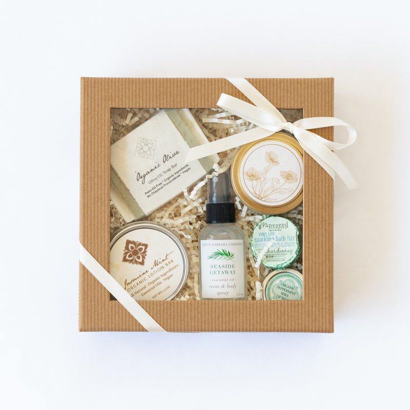 Clear lid gift box with spa essentials and California candle tied with ribbon