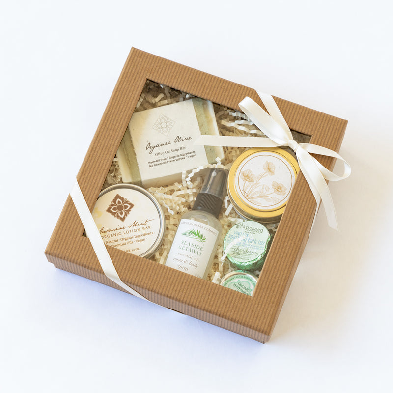 Clear lid gift box with spa essentials and California candle tied with ribbon