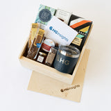 The HG Insights Customer Welcome Gift includes a wood box with sliding lid, branded Yeti mug, biscotti, jam, chocolate, tea, and a greeting card—perfect for making any occasion memorable.