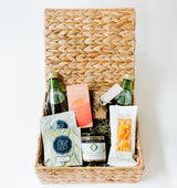 The Light Afternoon Treats basket, open to reveal two Perrier bottles, California gummy bears, Seep Lho tea, tapenade, handcrafted chocolate truffles, and rustic bakery sourdough flatbread—the perfect afternoon snack.