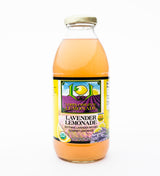A clear glass bottle of Lori's Lavender Lemonade with a yellow cap, featuring lemons and lavender on the label. This soothing, refreshing lemonade captures Ojai’s charm with its lavender-infused gourmet flavor.