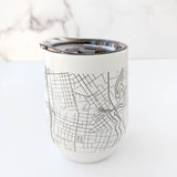 The Map of Napa Insulated Wine Tumbler, featuring a detailed black street map on white with a clear lid, sits on a white surface against a subtle marble background.