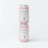 Two cans of Margerum Santa Barbara County Riviera Rosé Can are stacked vertically against a white background, featuring a pink floral design, black text, and a small black tree logo near the bottom.