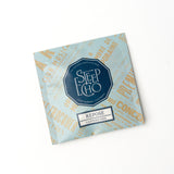 The Repose Single Tea Sachet by Steep Echo is a caffeine-free blue packet featuring a calming chamomile and olive leaf blend, with a hexagon logo and vintage-style text accenting the white surface.