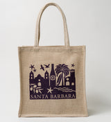 The Santa Barbara Skyline Tote is a tan jute cotton bag with rope handles, featuring a dark purple graphic of local landmarks, palm trees, birds, and waves with “Santa Barbara” at the bottom.