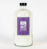 A clear glass bottle filled with white bath salts features a purple label reading "Santa Ynez Lavender Bath Salts," made with organic lavender oil and New Zealand sea salt.