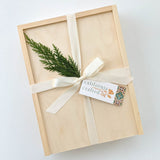 Sweet Tidings Holiday Gift Box: filled with gourmet treats, tied with cream ribbon, festive greenery & holiday tag.